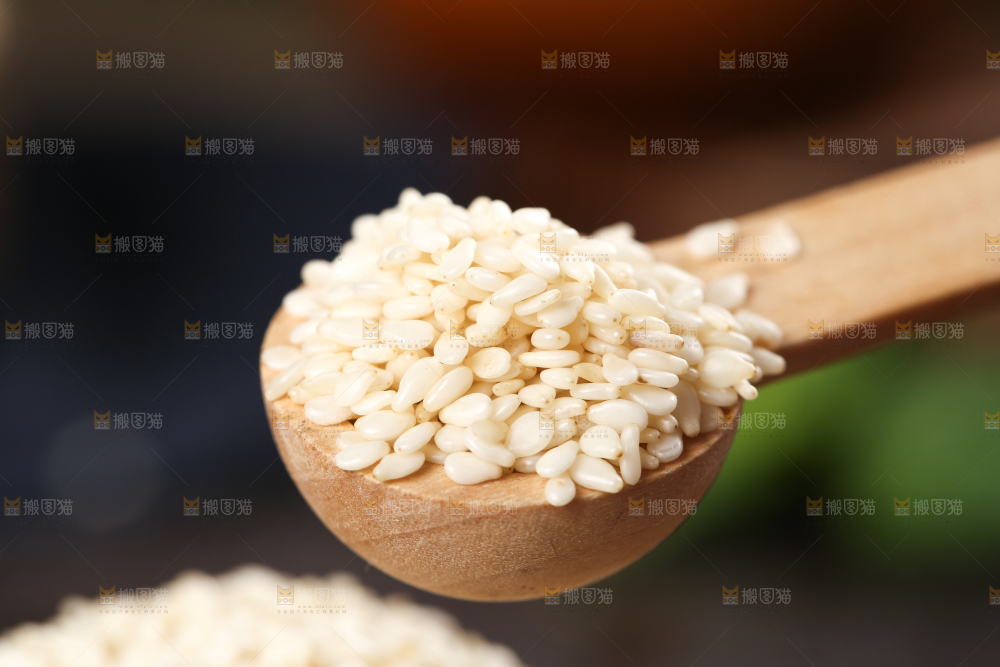 黑底上勺子里挖着脱皮白芝麻