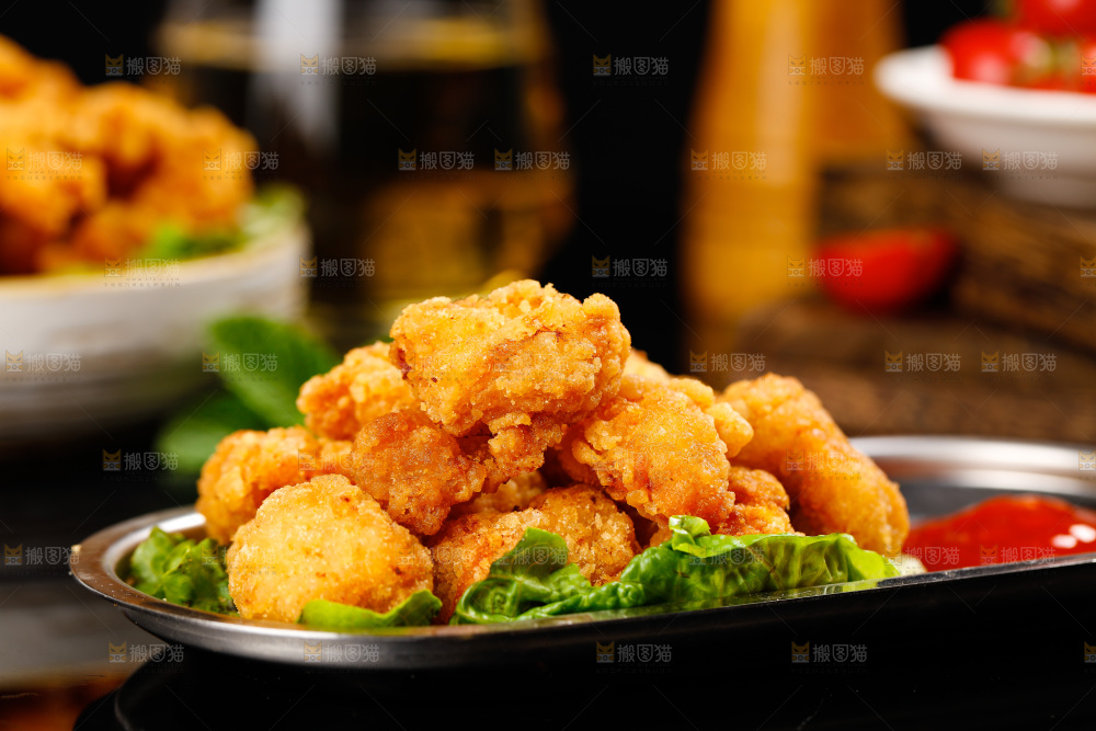 黑底上放着一盘油炸鸡米花