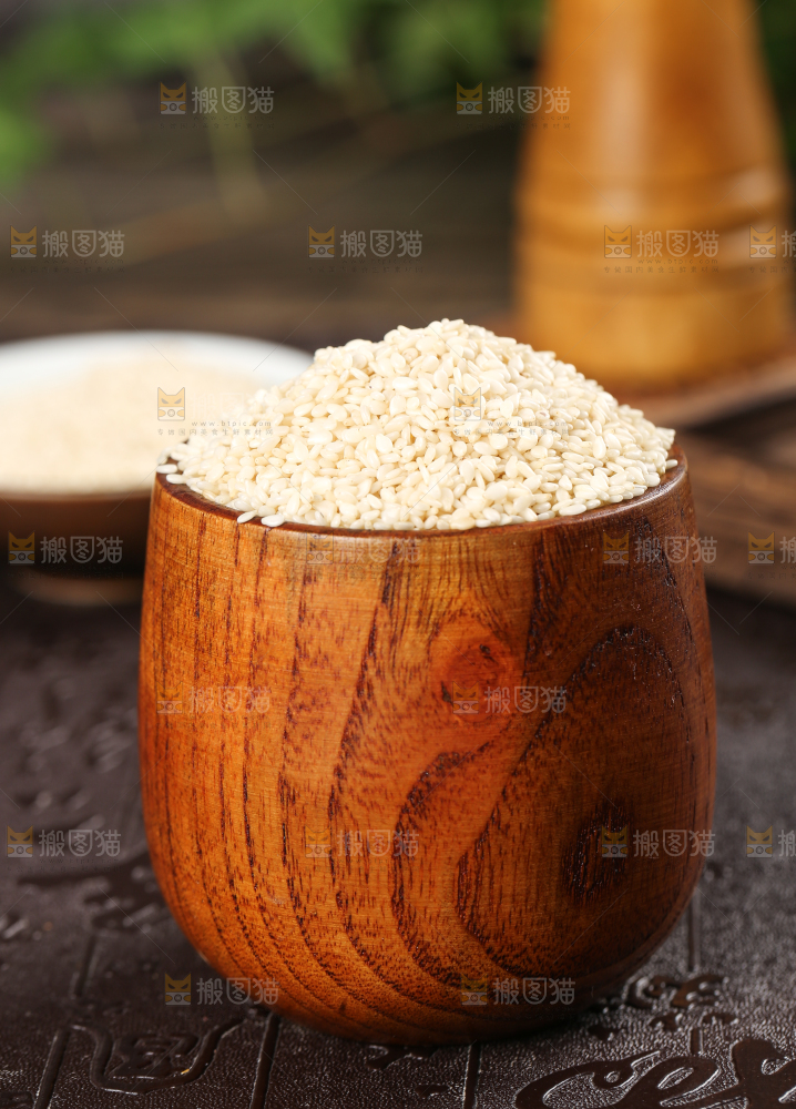 黑底上杯子里装着白芝麻仁