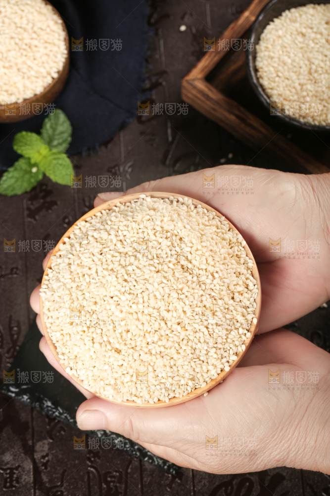 手上端着一盘白芝麻仁