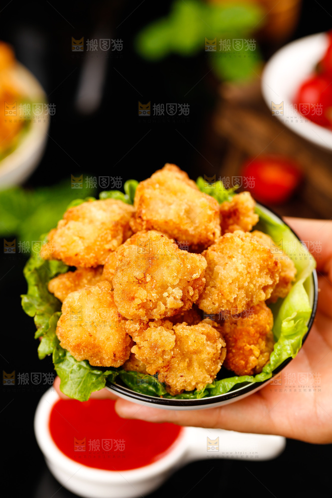 手上端着一碟油炸鸡米花