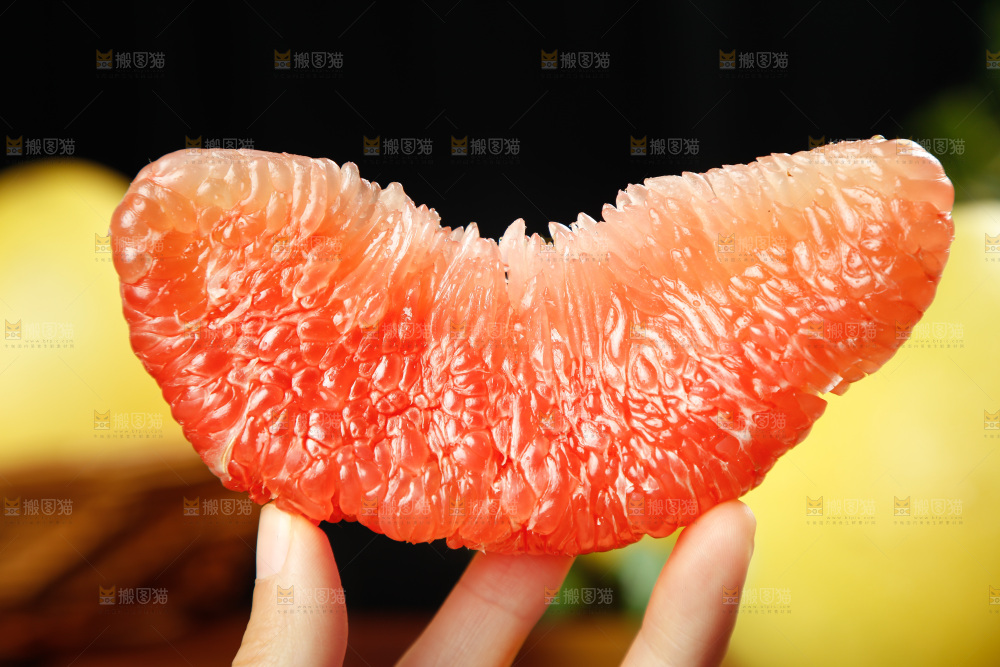 手上拿着红心蜜柚果肉