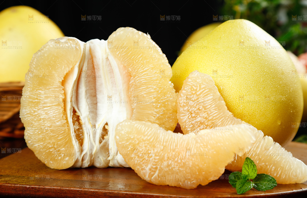 木板上放着蜜柚和白心蜜柚果肉