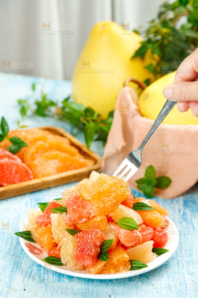 浅蓝底上放着一盘平和三色蜜柚