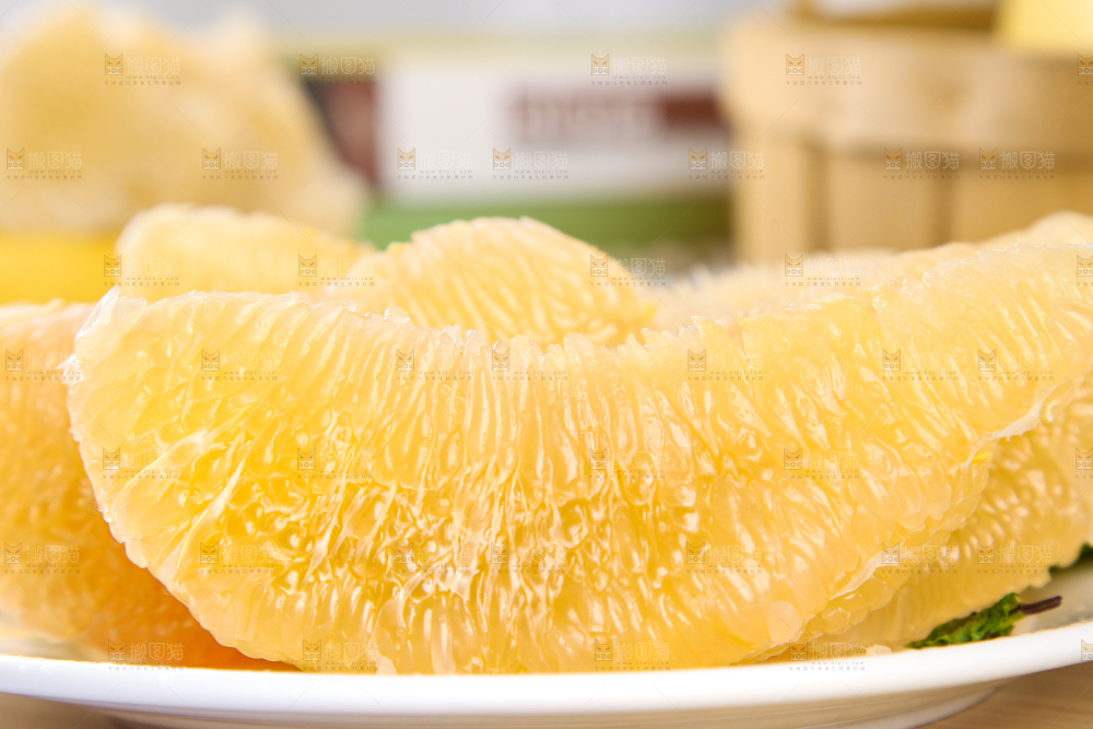 木板上放着一盘白心蜜柚果肉