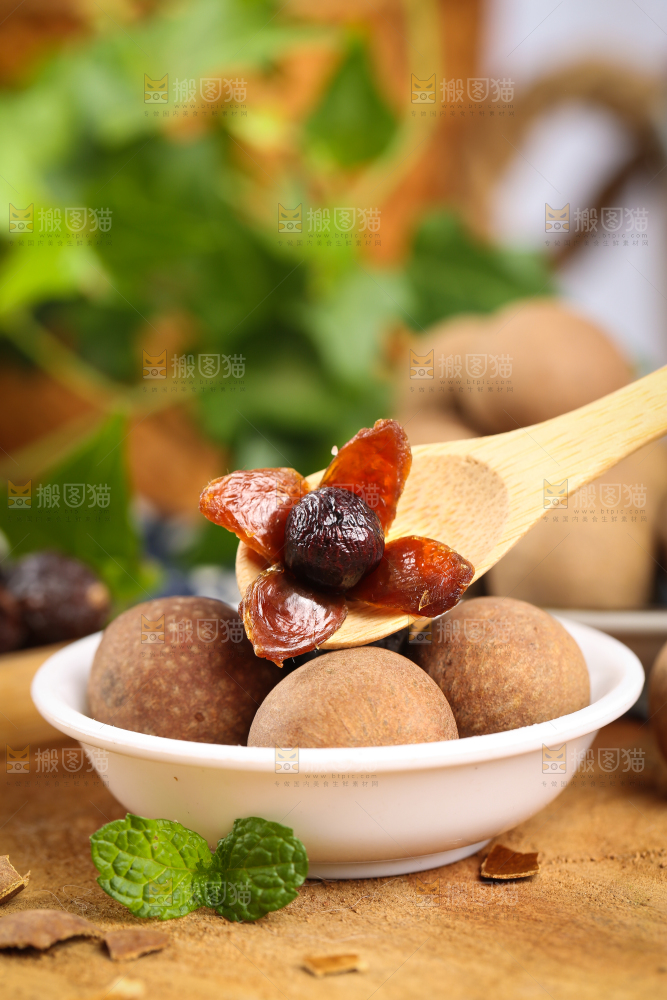 木底上一碟桂圆和勺子上挖着桂圆果肉