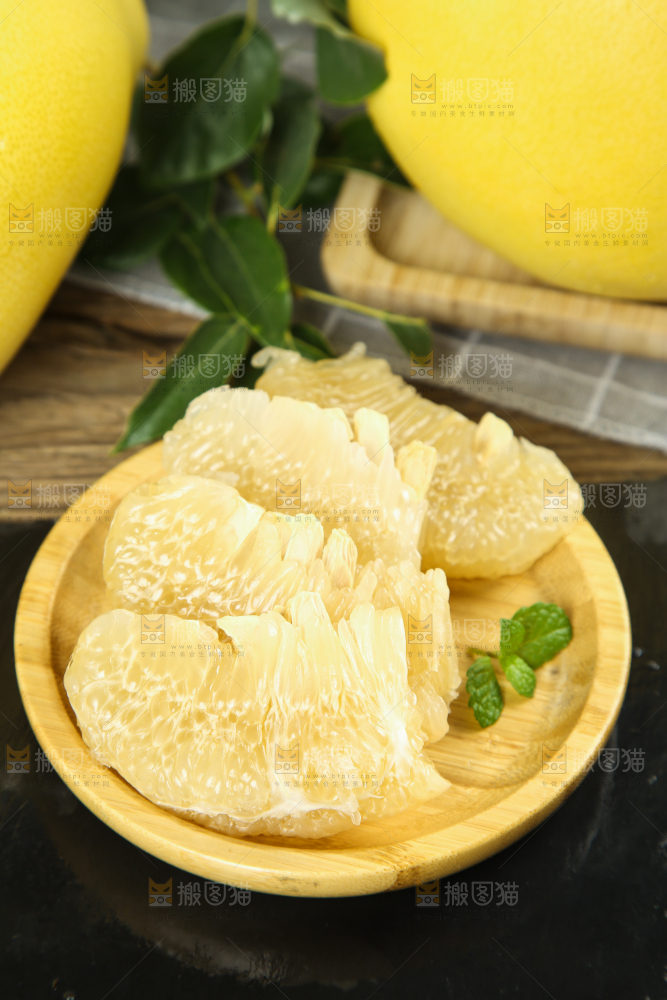 黑底上放着一盘白心蜜柚