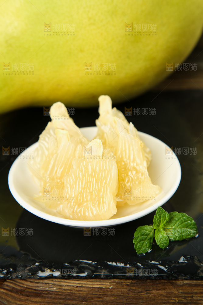 黑底上放着一盘白心蜜柚