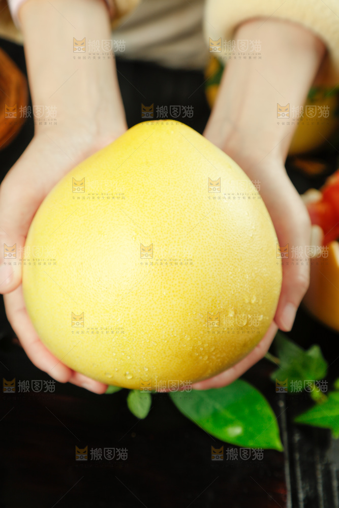 手上拿着蜜柚