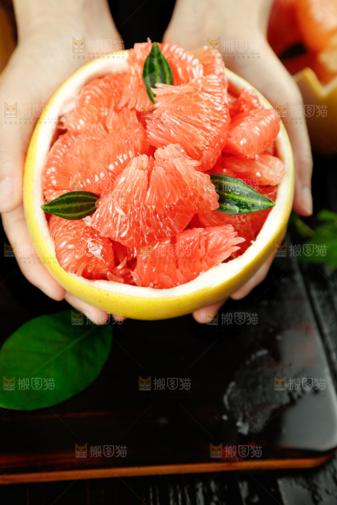 手上拿着红肉蜜柚