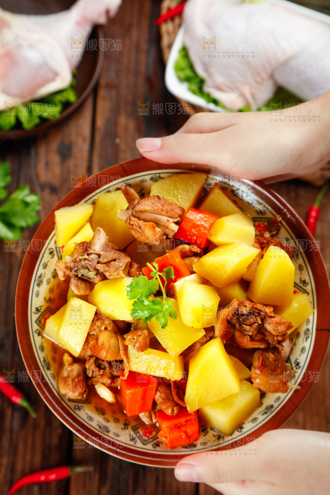 盘子里放着土豆烧鸡腿
