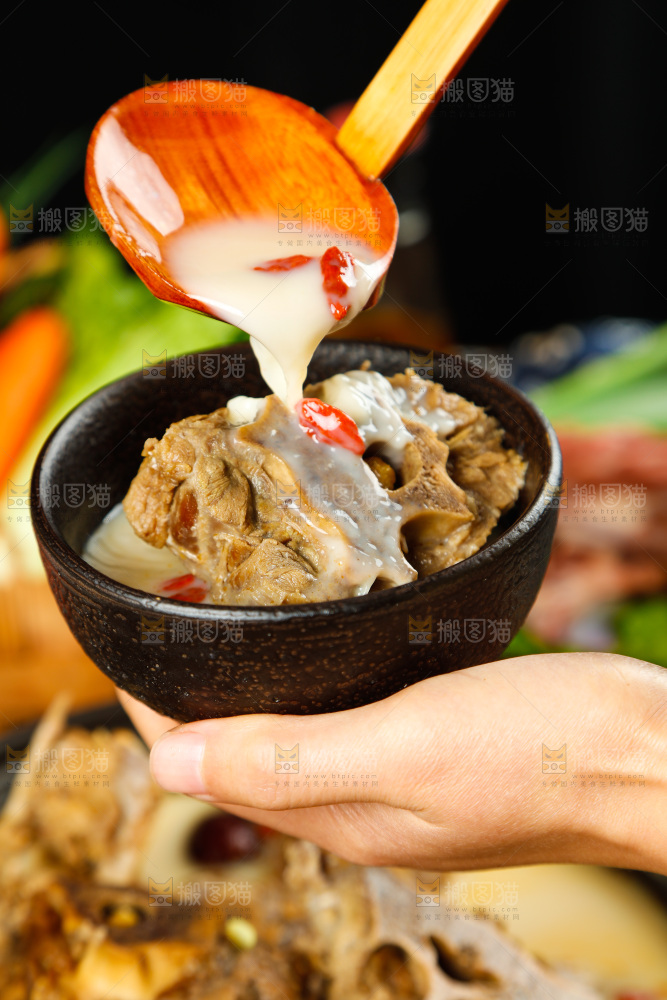 手里端着一碗羊蝎子汤