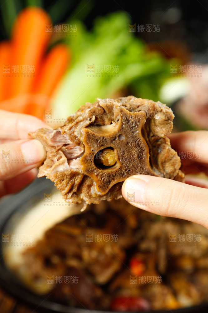 手里拿着煮熟的羊蝎子