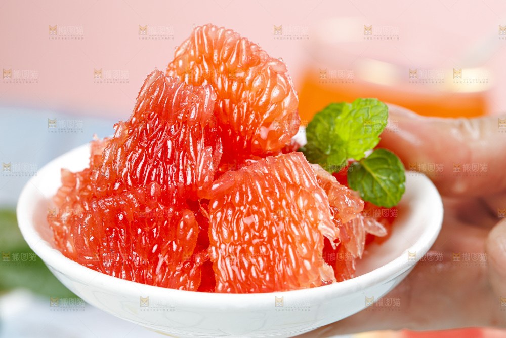 手拿一碟红心西柚果肉