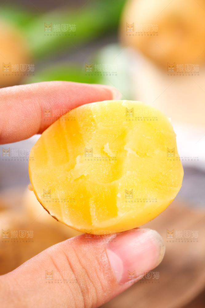 手拿剥皮的黄心熟土豆