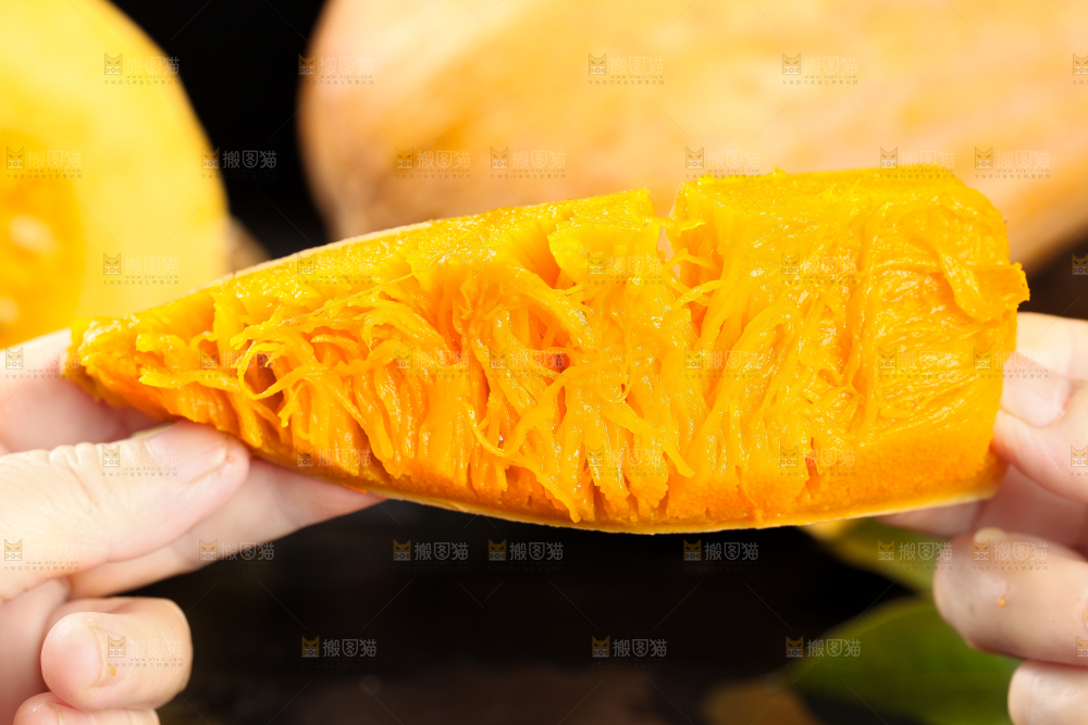 手拿切开的熟老南瓜
