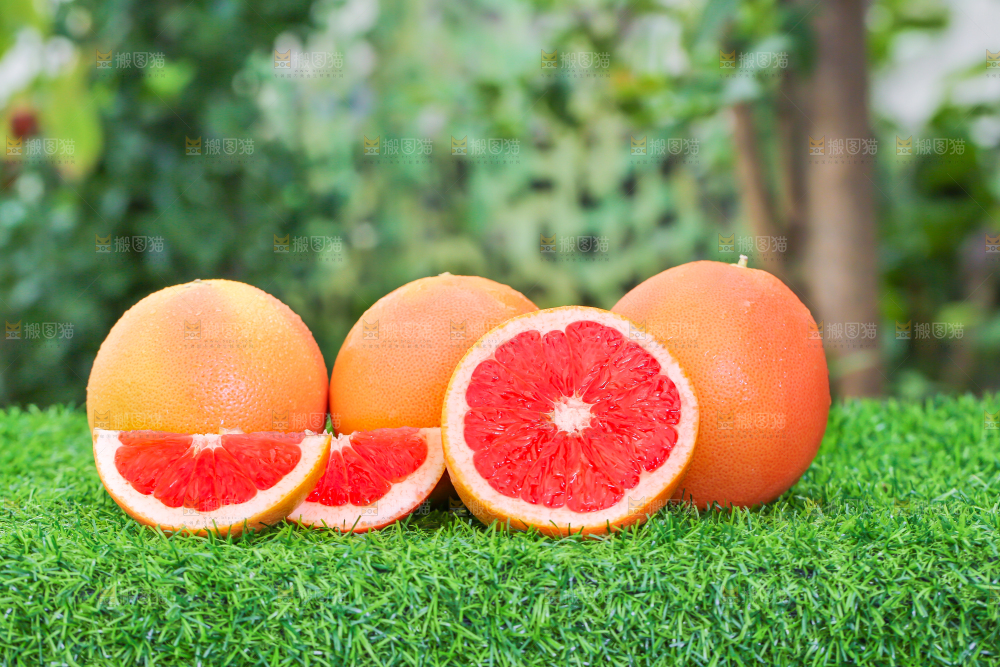 草地上放着切开的红心西柚