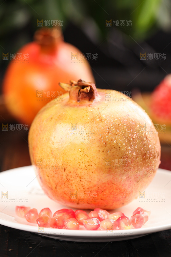 黑底上放着一盘石榴