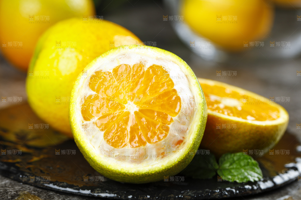 黑石板上放着切开的夏橙