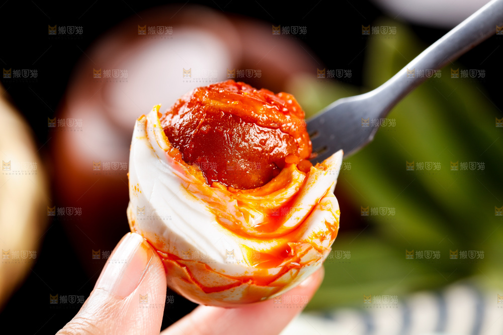 深底上叉子叉着海鸭蛋黄