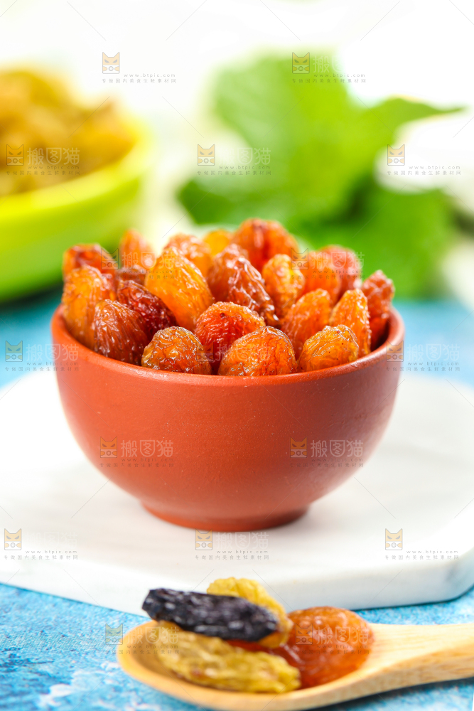白石板上放着一碗玫瑰红葡萄干