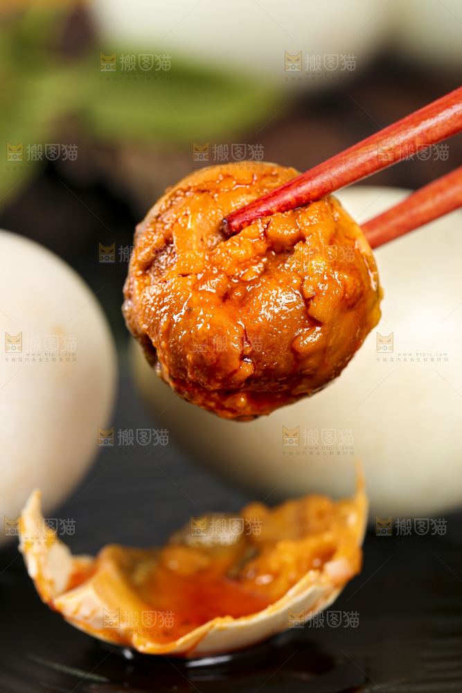 黑底上筷子夹着红心咸鸭蛋