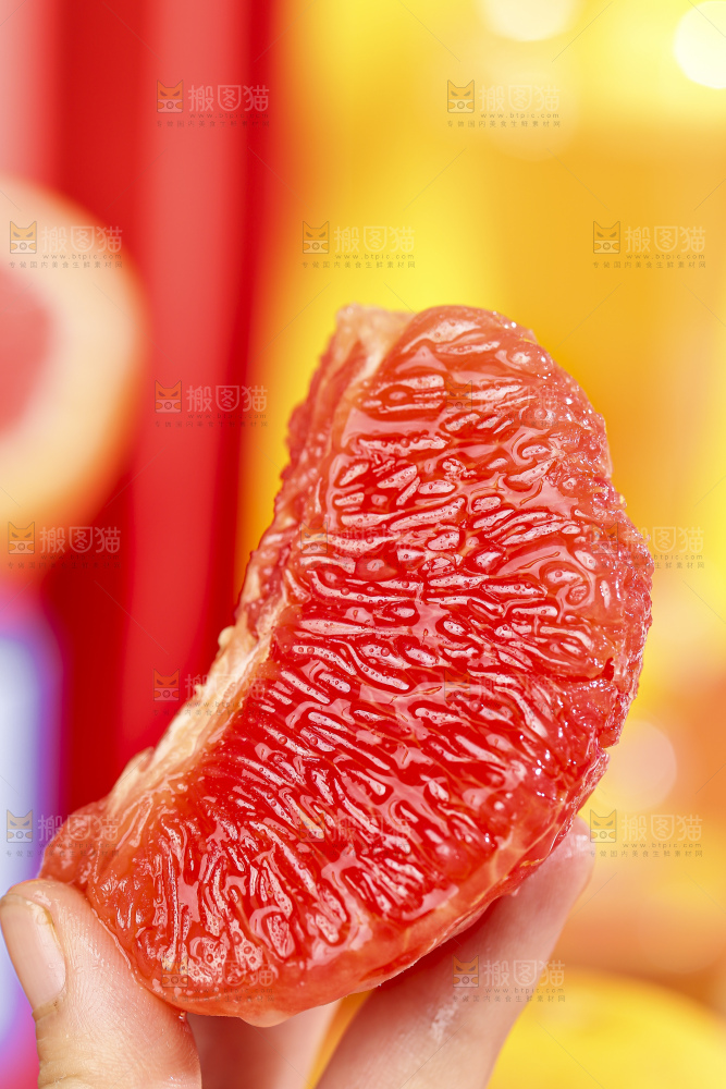 手拿着剥皮的红心葡萄柚果肉
