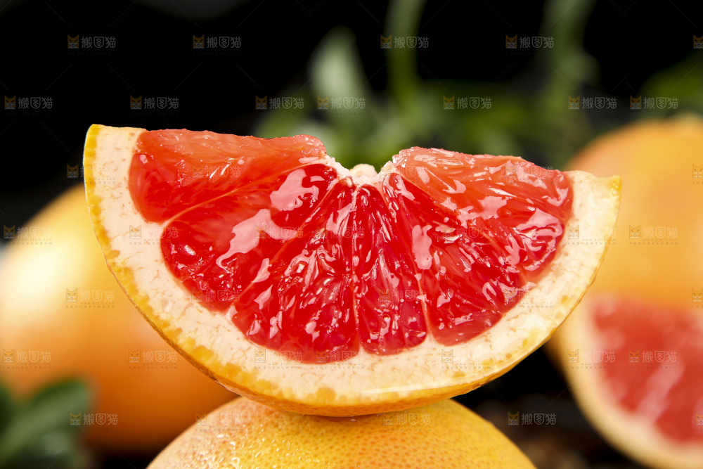 黑石板上放着切开的红心葡萄柚