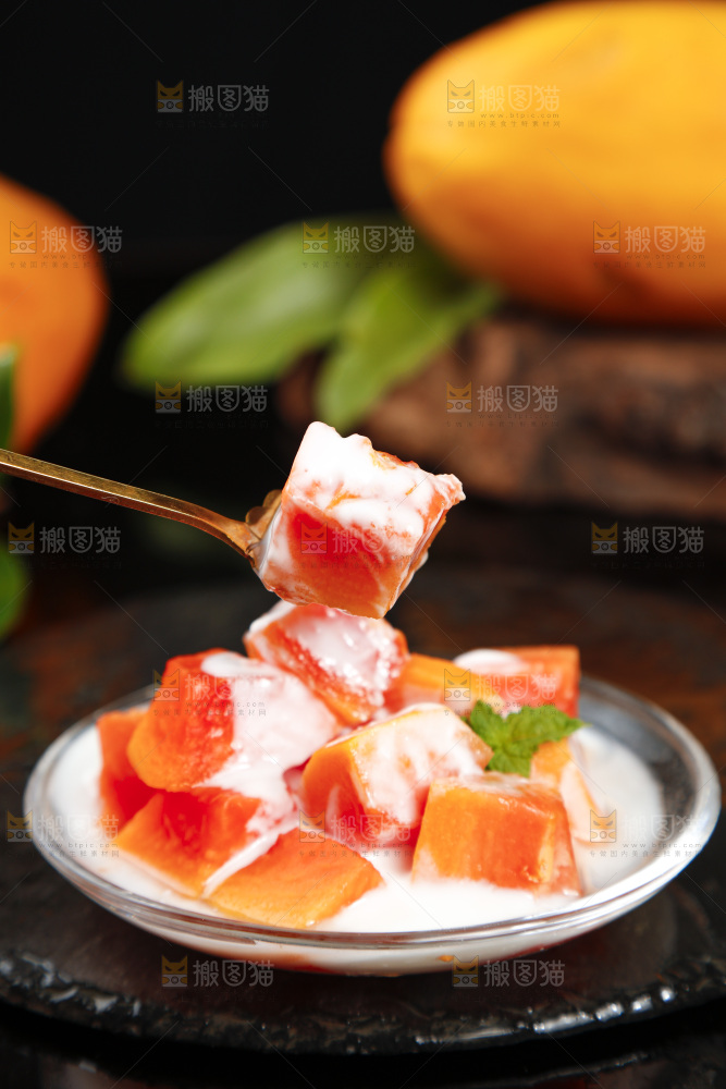 黑底上叉子叉着一块红心牛奶木瓜