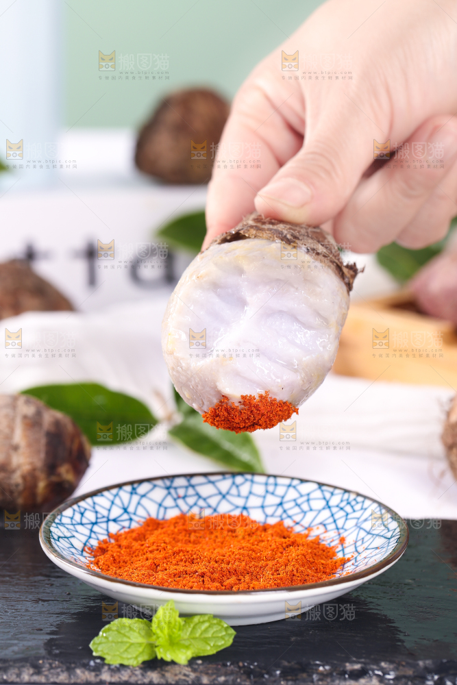 手拿蘸辣椒的香芋