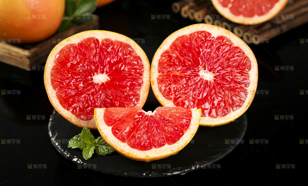 黑石板上放着切开的红心葡萄柚