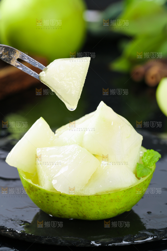 黑底叉子叉着一块削皮的苹果梨果肉