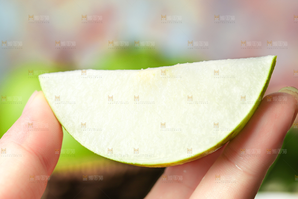 木底上手拿着切开的苹果梨