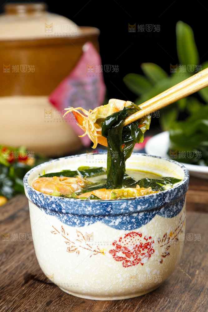 木底上放着一杯裙带菜大虾汤