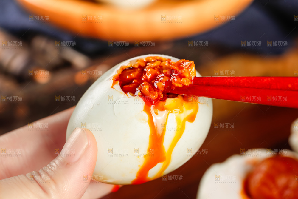 深底上筷子夹着流油的海鸭蛋黄