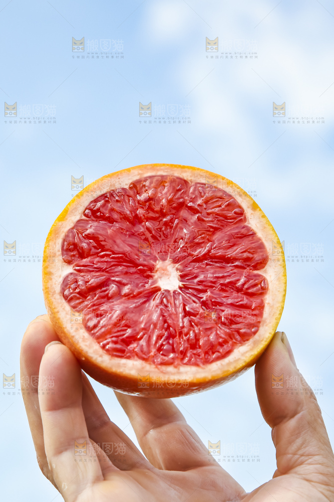 手拿切开的红心西柚