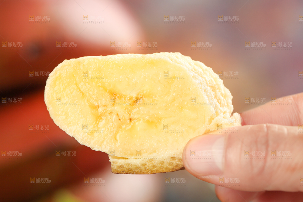 浅底上手拿着一块红皮香蕉