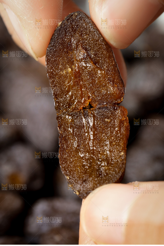手拿掰开的黑枣