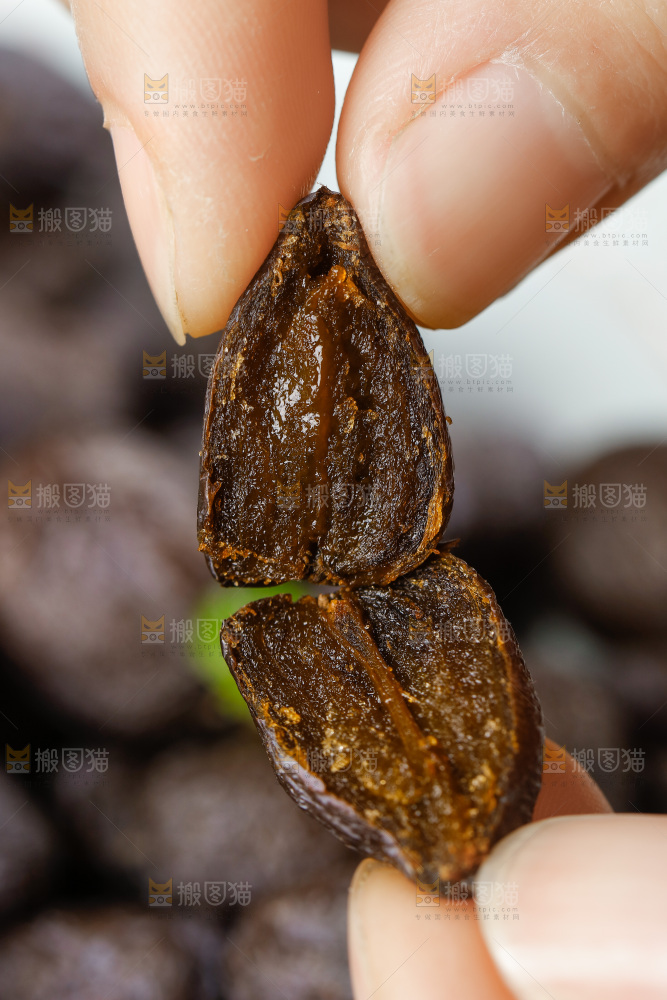 手拿掰开的黑枣