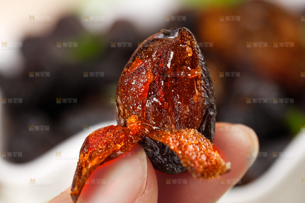 手拿掰开的黑枣