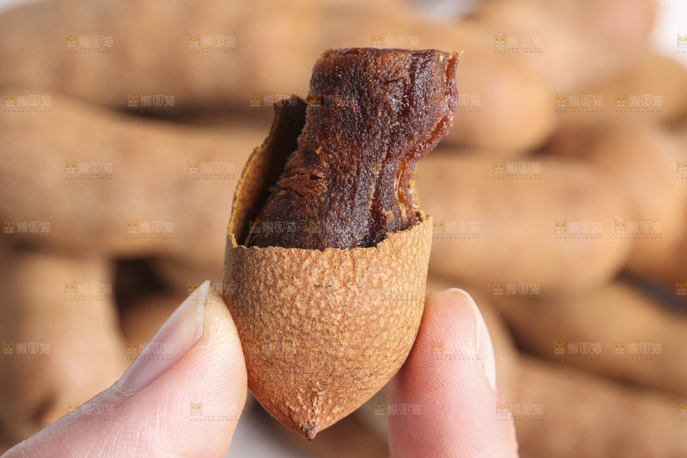 手里拿着带壳罗望子