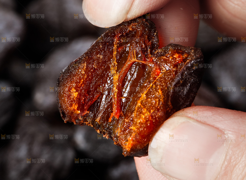 手拿掰开的黑枣