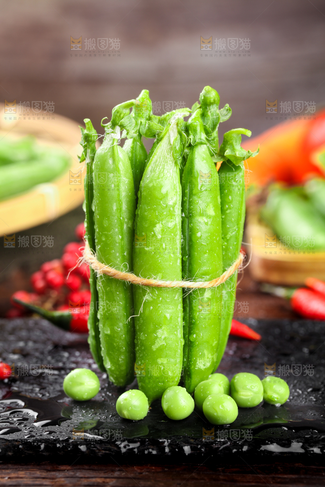 黑底上放着一捆新鲜豌豆荚