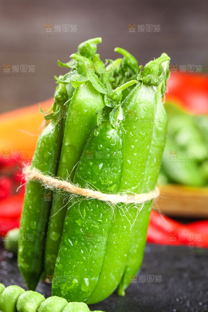 黑底上放着一捆新鲜豌豆荚