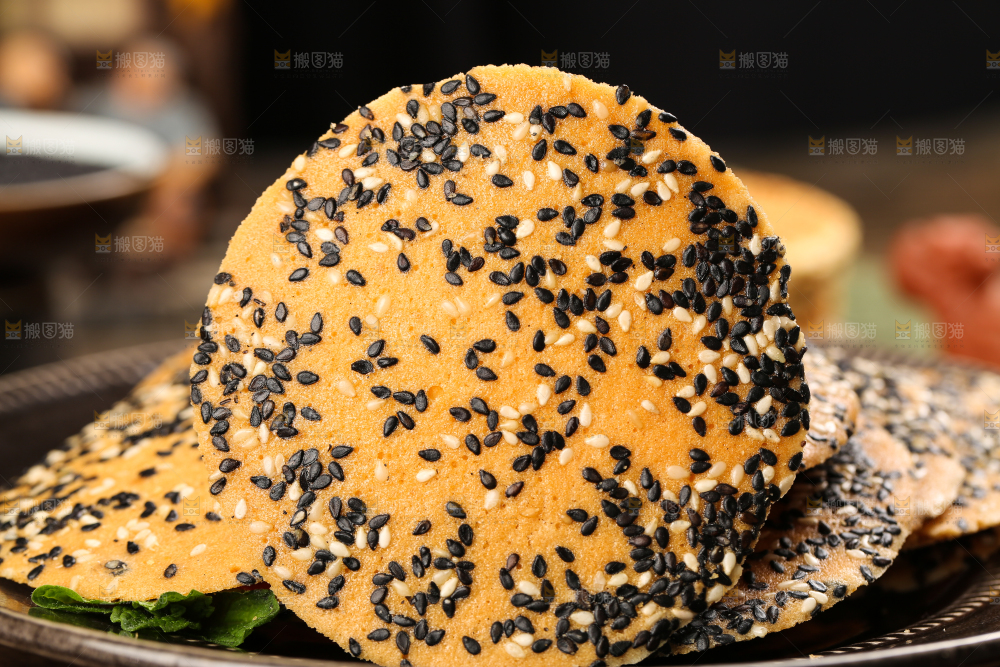 木板上放着手工芝麻饼