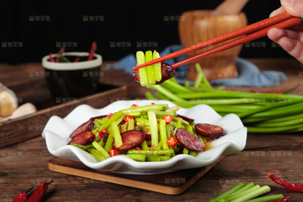 筷子夹着腊肠炒蒜苔