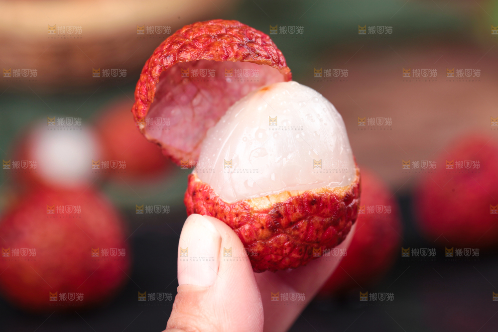 手拿剥皮的新鲜荔枝