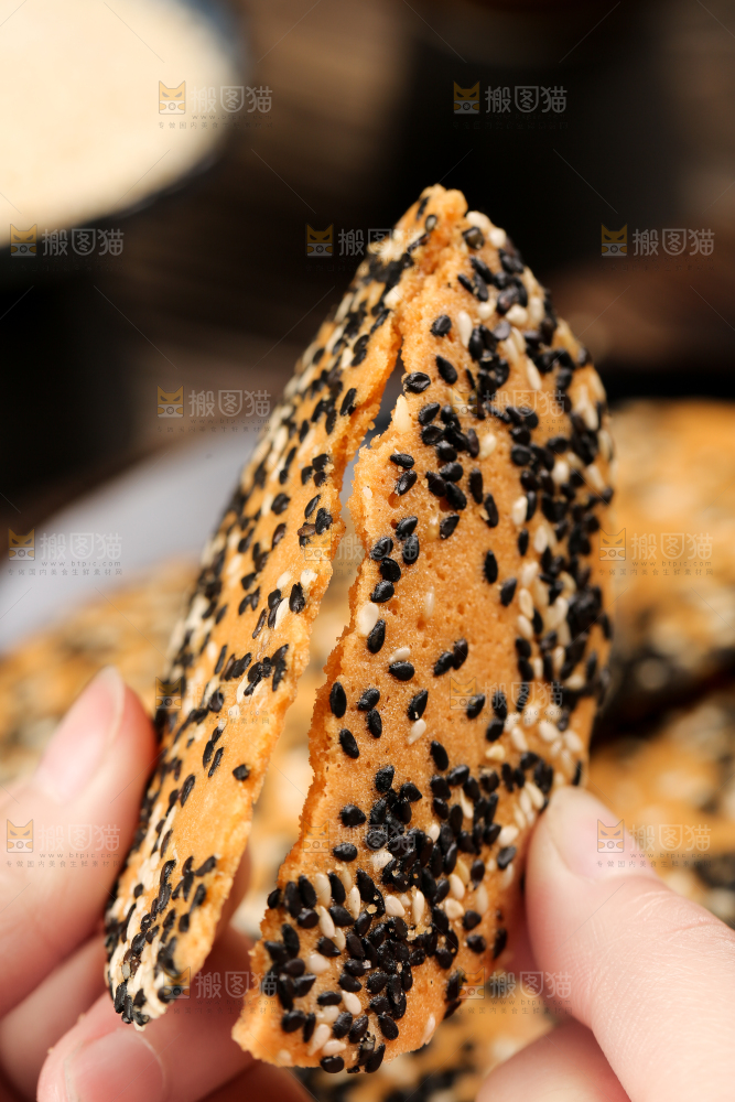 手里拿着芝麻薄脆饼