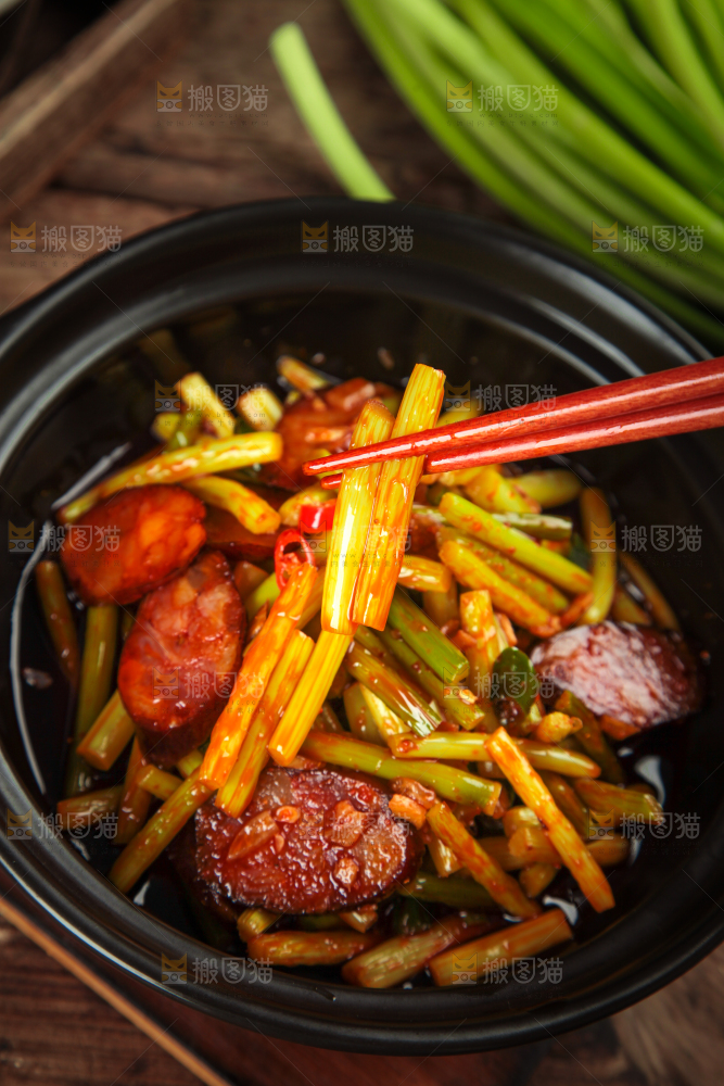 筷子夹着蒜苔炒腊肠