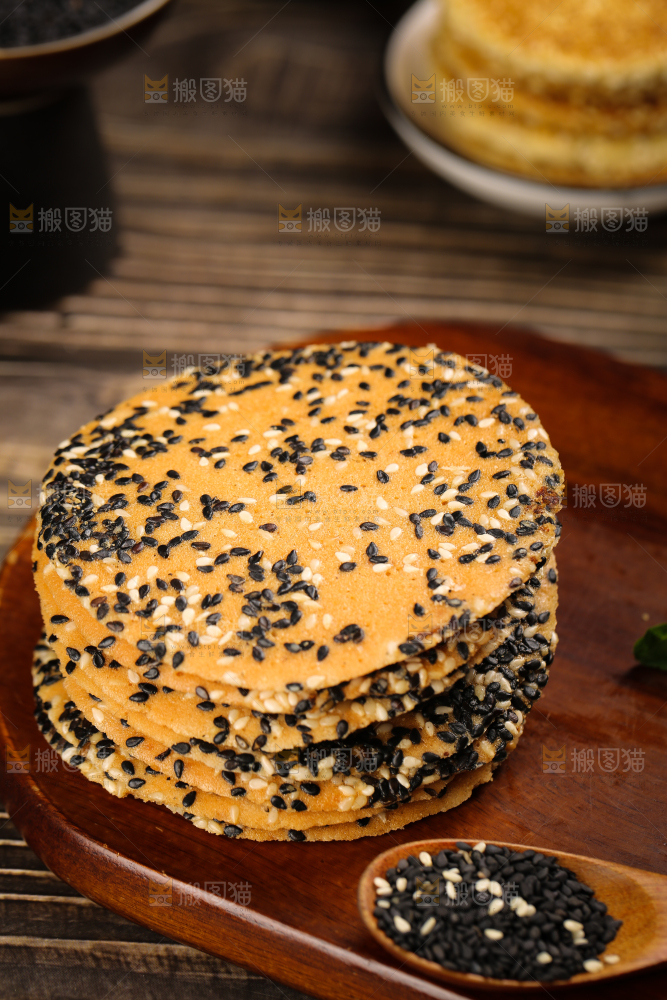 木板上放着手工芝麻饼
